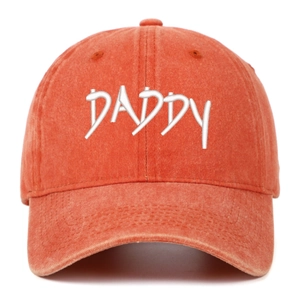 Close-up of DADDY embroidery on vintage washed orange cotton baseball cap with curved brim