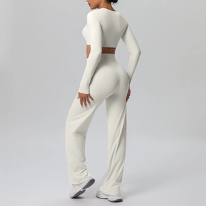 Detail view of cream long sleeve yoga top and high waist wide leg pants set on a model