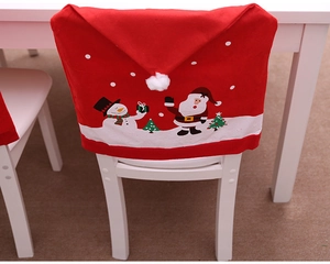 Detail of red Santa Claus and snowman printed chair cover with festive white pom-pom