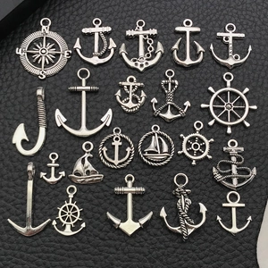 Detail of nautical alloy charms including anchors and rudders on black textured background