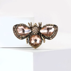 Close-up of a sparkling bee brooch featuring champagne crystals and fine rhinestone inlay