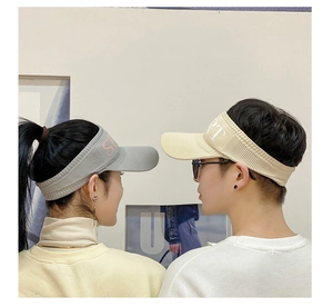 Detail of grey and off-white breathable knitted sun visors on models for sports