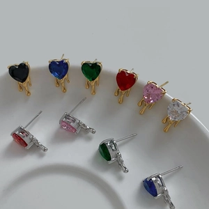 Colorful heart zircon stud earrings set in melting drip design on a ceramic plate