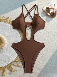 Macro view of chocolate cutout swimsuit with metal heart clasp and ribbed texture
