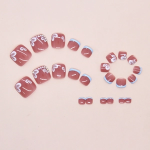 Dettaglio macro di unghie finte piedi blu francese e rosso bordeaux con fiori e strass
