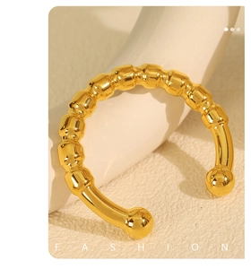 Detailed macro view of gold open cuff bracelet with spherical beaded texture and C-shape design