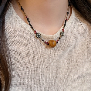 Detail einer Perlenkette mit gelbem Tigerauge-Stein und ethnischen böhmischen Mustern