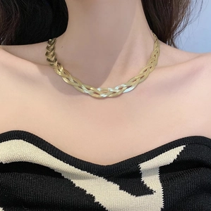 Triple layered gold stainless steel snake bone necklace worn by a fashion model