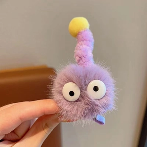 Détail d'une pince à cheveux en peluche violette avec de drôles de grands yeux doux