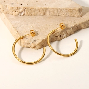 Minimalist 18K gold plated stainless steel C-shape earrings on a neutral stone display