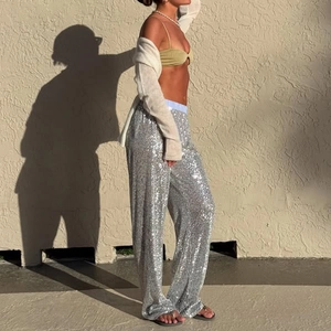 Detail of silver sequin wide-leg pants showing sparkling texture in natural outdoor light