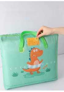 Detail of inserting a yellow name label into the clear pocket on a dinosaur storage bag