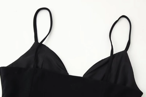 Close-up of black spaghetti straps and plunging V-neckline stitching on a slim dress