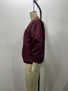Close-up of burgundy bomber jacket showing metal zipper and ribbed cuffs for women