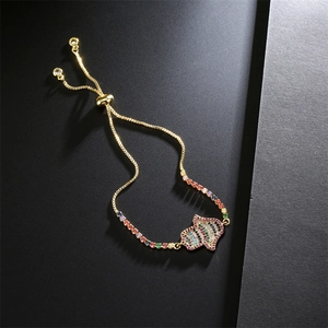 Gros plan du bracelet Main de Fatma en or avec zircons colorés et chaîne ajustable