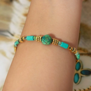 Bohemian natural turquoise beaded bracelet with golden spacers on a model's wrist