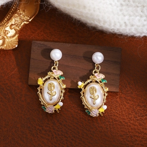 Macro shot of French vintage square pearl drop earrings with colorful enamel flowers