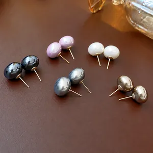 Elegant multi-color pearl stud earrings set on premium leather background for women