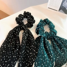 Dettaglio di elastici per capelli a pois pieghettati in seta nera e verde scuro