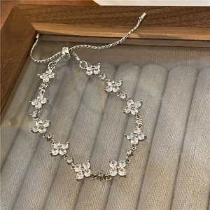 Detailed close-up of a silver flower star bracelet with sparkling white zircon stones
