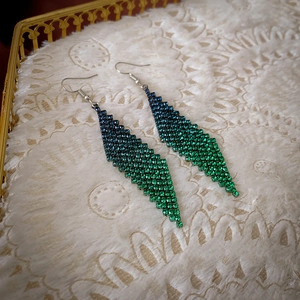 Détail de boucles d'oreilles losange avec strass dégradés bleu-vert et crochets argentés