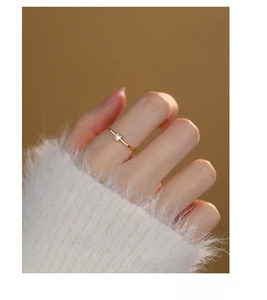 Detail of s925 silver heart ring with white zircon on hand with white knit sleeve