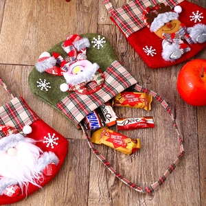 Top view of festive felt Christmas gift bags with 3D Santa and reindeer on wood surface