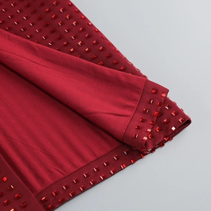 Détail de la robe de soirée rouge foncé avec ornements de strass carrés brillants