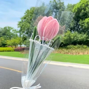 Detailed view of pink plush tulip bouquet with LOVE branding in clear lace packaging