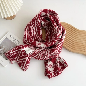 Detail of red and white knit scarf featuring geometric jacquard pattern and thick texture