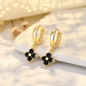 Elegante goldene Creolen mit schwarzem Kleeblatt-Anhänger und funkelnden Zirkonia-Steinen