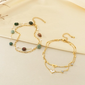 Cavigliera doppia in oro con ciondoli a cuore, inserti in conchiglia e perline colorate