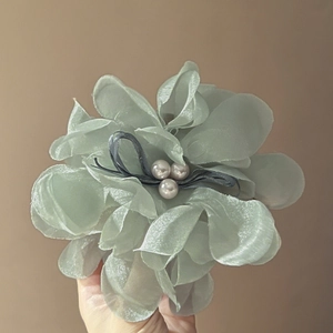 Nahaufnahme der hellgrünen Organza-Blumen-Haarklammer mit weißen Perlen-Details