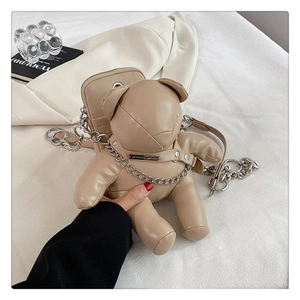 Close-up of cute beige bear crossbody bag with metal chain and zipper detail