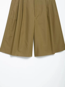 Detail of khaki wide-leg shorts featuring high-density twill fabric and pleated texture