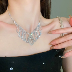 Close-up of sparkling silver tassel necklace and bracelet set with rhinestones on model