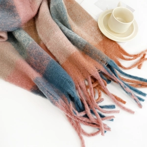 Close-up of soft mohair scarf with pink and blue checkers and long fringed tassels