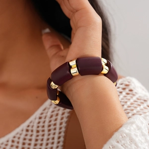 Close-up of retro oval acrylic bead bracelet with gold metal spacers on model wrist