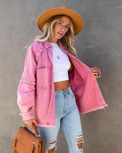 Detail of pink distressed denim jacket featuring heavy frayed edges and oversized fit
