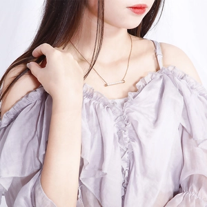 Collier élégant en acier inoxydable doré avec pendentif barre serti de zircons sur mannequin