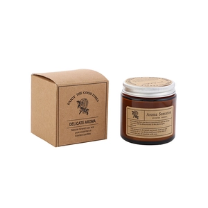 Amber glass jar scented candle with silver lid and kraft gift box on white background