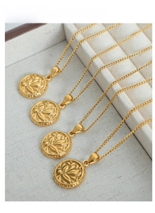Detail of four golden round floral necklaces with embossed patterns on jewelry display
