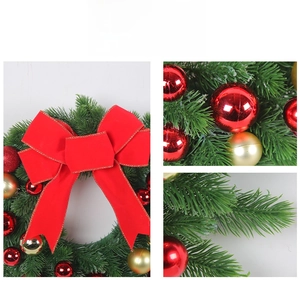 Detailed view of artificial Christmas wreath with red bow and metallic gold ornaments