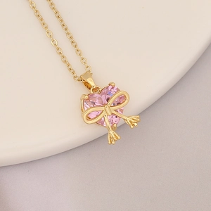 Macro shot of 18K gold plated pink heart pendant with a delicate golden butterfly detail