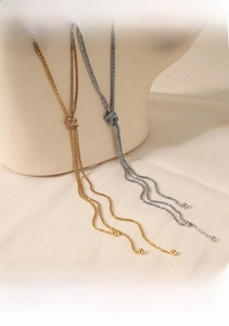 Detail of hand-polished Y-shaped knot sweater chain with tassel and metal beads