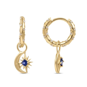 Macro detail of gold hoop earrings featuring blue gemstone moon and star pendants with pavé diamonds