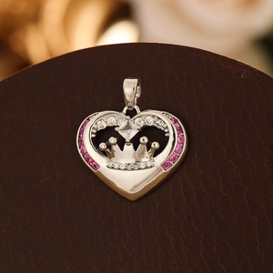 Macro d'un pendentif cœur couronne avec pierres roses sur fond de cuir marron