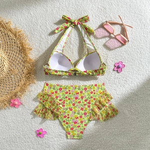 Bikini floral à volants et licou posé à plat sur un fond en fausse fourrure blanche