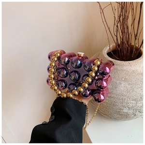 Detailed view of acrylic gradient beaded bag with golden chain strap and round handles