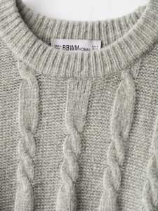 Close-up of the grey cable knit sweater neckline with a fine stitched crew neck finish